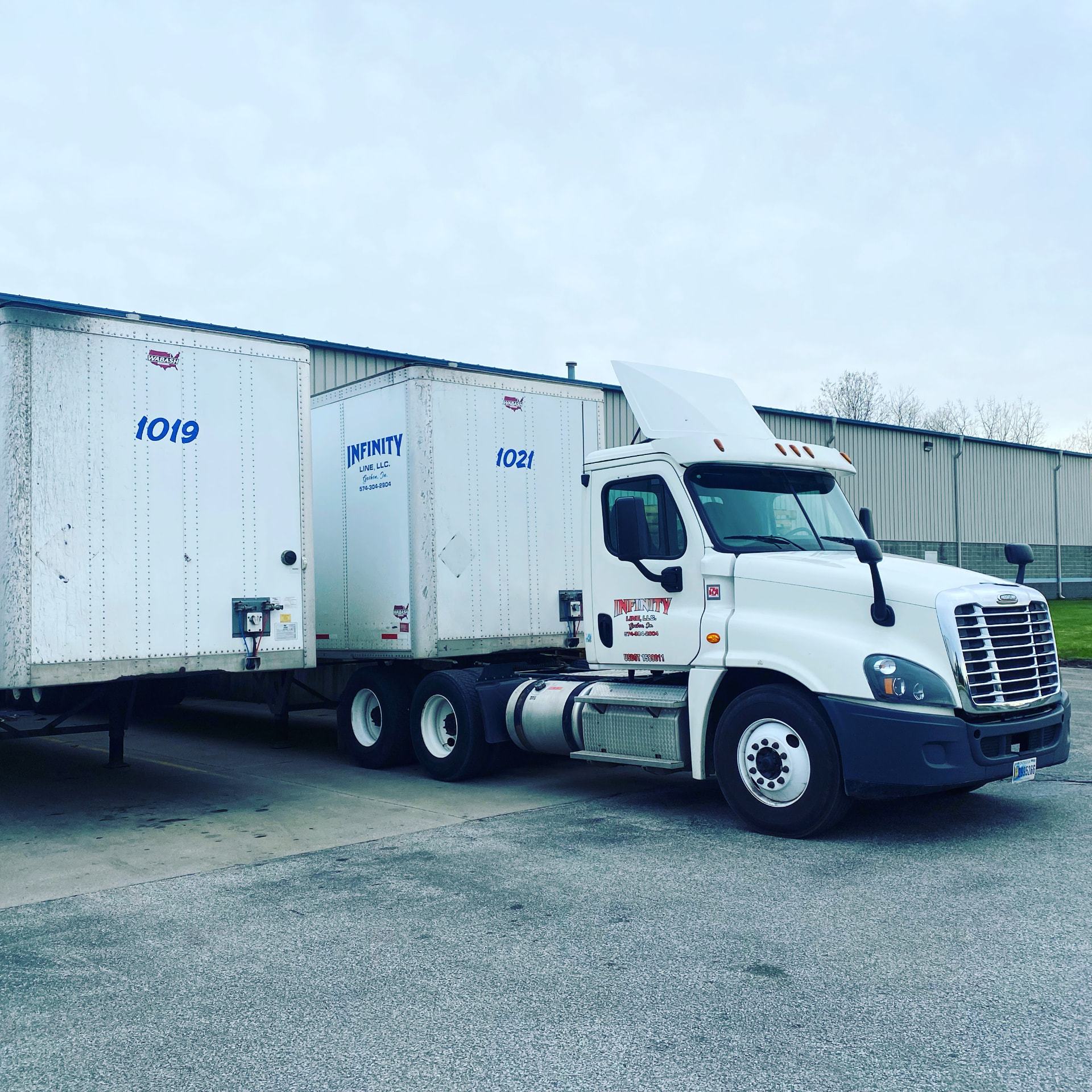 Infinity Line day cab tractor with two dry van trailers at the Elkhart terminal